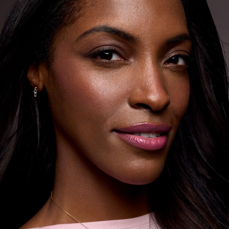 Close-up of a woman with glowing cheeks and pink lips